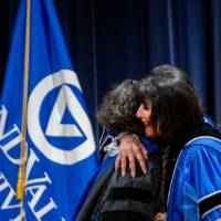 President Mantella and woman embrace in a hug on stage